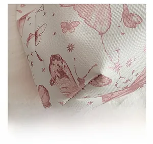 Gros plan du motif papillon rose sur sac seau en cuir blanc avec coutures précises