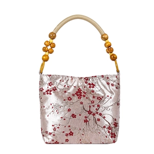 Satin champagne bucket bag with red cherry blossom embroidery and wooden bead handles