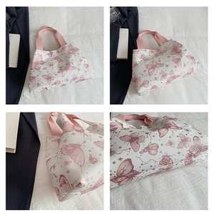 Détail du sac cabas en toile blanche avec motifs papillons roses et anses en tissu