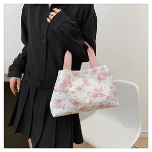 Sac fourre-tout blanc à imprimé papillons avec anses roses porté par un mannequin