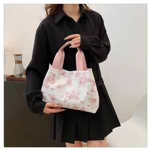 Détail du sac cabas en toile avec imprimé papillon rose et poignées en tissu souple