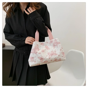 Détail de l'imprimé papillon rose sur sac cabas blanc avec poignées roses