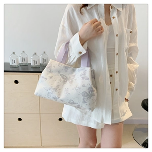 Détail du sac fourre-tout à imprimé papillon avec anses violettes et toile blanche