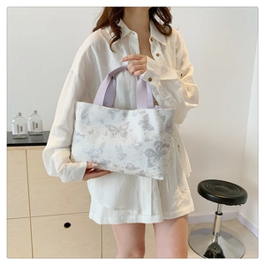 Détail du sac cabas blanc avec imprimé papillon gris et anses lilas en décor de vie
