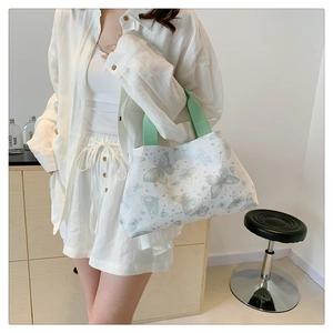 Vue détaillée du sac cabas blanc avec imprimé papillon vert et bandoulière large confortable