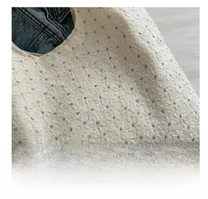 Close-up of white daisy embroidery and canvas texture on an elegant tote bag