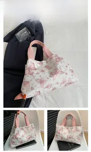 Détail de l'imprimé papillon rose sur un sac cabas blanc avec anses roses et étoiles
