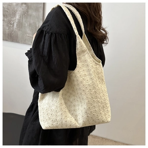 Detail of floral lace embroidery on cream canvas tote bag with black butterfly accents