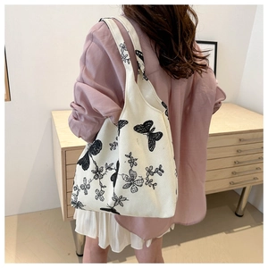 Floral canvas tote bag with black butterfly embroidery on beige fabric, casual shoulder bag