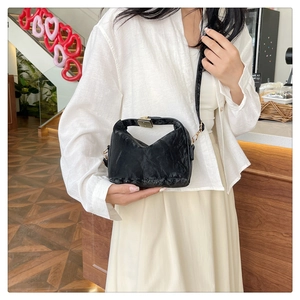 Detailed view of the black wrinkled PU leather handbag shown in a lifestyle crossbody look