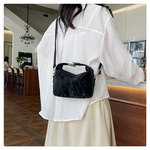 Detail view of the black textured PU leather handbag with elegant silver metal buckle