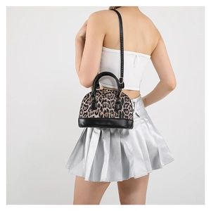 Leopard print shell handbag with black round handles and gold hardware on a model