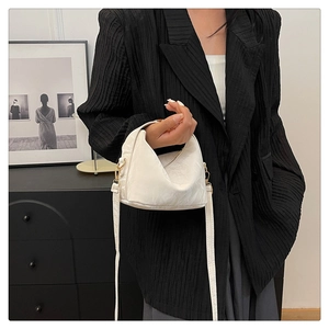 Close-up of white soft PU leather handbag featuring golden metal buckles and a long strap