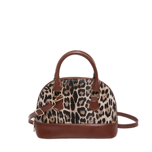 Chic shell-shaped crossbody bag featuring leopard print texture and brown leather trim
