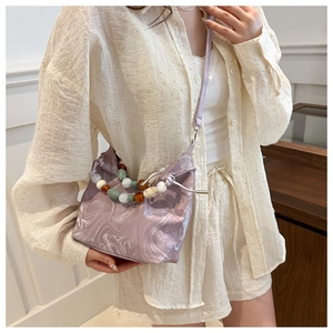 Close-up of lavender marble pattern handbag with decorative colorful bead chain