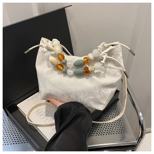 Detail of white marble textured cloud bag with colorful agate beaded handles and drawstring