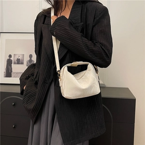 White textured faux leather handbag with metal buckle closure and adjustable strap