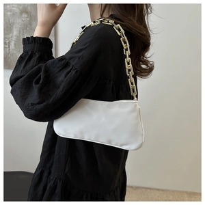 Dettaglio della borsa a spalla in pelle PU bianca con una vistosa catena dorata a maglie