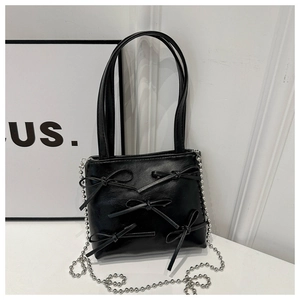 Close-up of black PU leather bucket bag featuring decorative bows and silver bead chain
