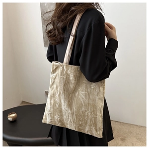 Detail of champagne velvet tote bag with elegant bamboo leaf embroidery and silky texture