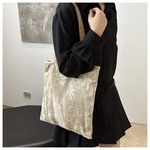 Detail of bamboo leaf embroidery on beige velvet tote bag with shoulder strap