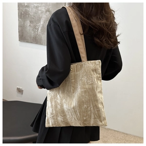 Detail of champagne gold velvet tote bag with bamboo leaf embroidery and metal buckle