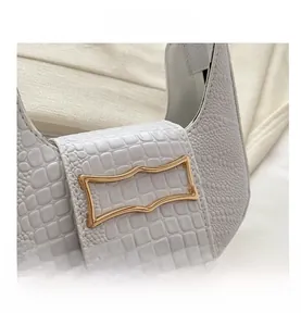 Detail of white crocodile and ostrich embossed leather with gold geometric clasp buckle