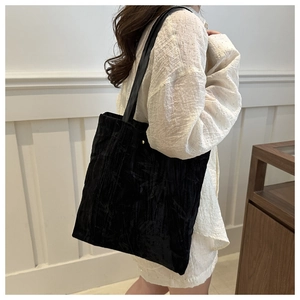 Close-up of black velvet tote bag featuring textured bamboo leaf pattern and shoulder strap