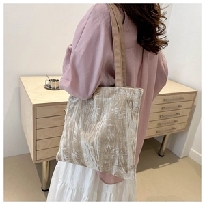 Detail showing texture of bamboo embroidery velvet tote bag on a model's shoulder