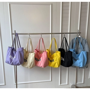 Μινιμαλιστικές πάνινες τσάντες tote με στάμπα Wonder σε έξι χρώματα σε κρεμάστρα
