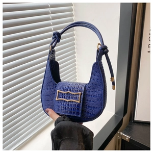 Detail of royal blue crocodile embossed crescent bag with a decorative gold metal buckle