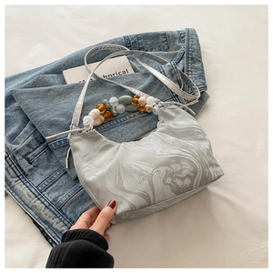 Détail du sac à main gris marbré avec poignée artistique en perles colorées