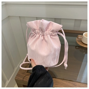 Close-up of light pink drawstring bucket bag with unique crinkled fabric texture