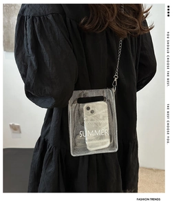 Close-up of clear PVC summer crossbody bag with glitter finish and silver chain strap