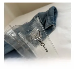 Macro shot of silver metal D-ring and spring hook on a transparent PVC beach bag