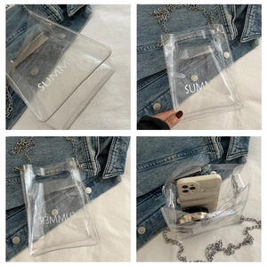 Detailed view of transparent PVC crossbody bag with silver chain and SUMMER text print
