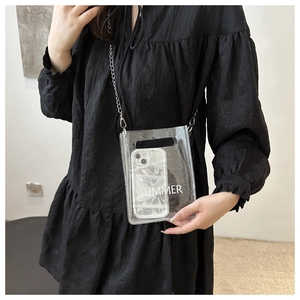 Close-up of a clear glitter PVC crossbody bag with silver chain and mobile phone inside