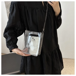 Detail of transparent PVC crossbody phone bag with silver glitter and summer text print