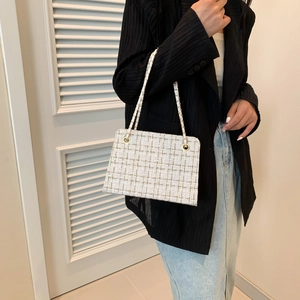 French style white tweed crossbody bag with gold chain strap on a black blazer model