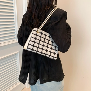 Classic black and white plaid tweed chain shoulder bag worn by model with denim skirt
