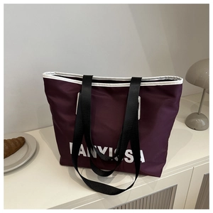 Detail of burgundy nylon tote bag with white piping and bold IANVSSA letter print