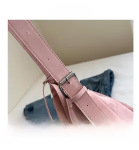 Detail of pink shoulder bag strap with adjustable silver buckle and matte texture leather