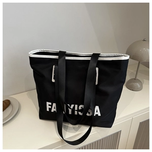 Detail of FANYISSA black nylon tote bag with white trim and reinforced fabric handles