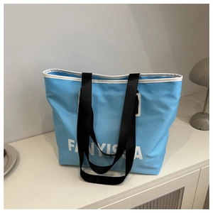 Close-up of a light blue waterproof tote bag with FANYISSA print on a white counter