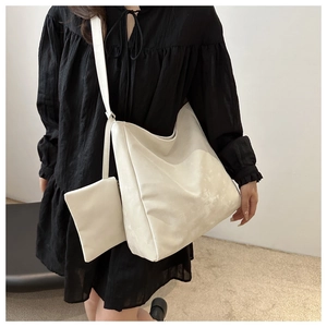 Dettaglio della borsa tote in ecopelle bianco crema e borsellino abbinato a spalla