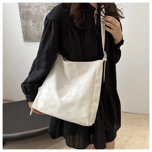 Dettaglio della borsa tote in morbida PU crema con tracolla regolabile e stile minimalista