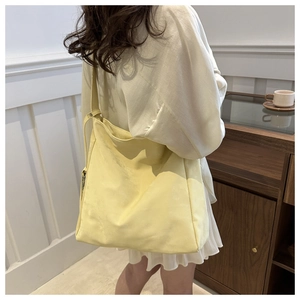Detail of light yellow suede tote bag showing soft matte texture and adjustable strap