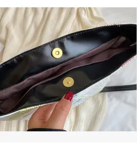 Gros plan détaillé du fermoir magnétique doré et de la texture tissée du sac beige