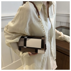 Retro plaid crossbody bag with gold chain strap shown on model in warm indoor setting