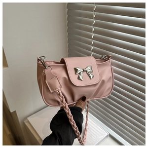 Détail du sac à main plissé rose montrant le nœud argenté et la bandoulière tressée